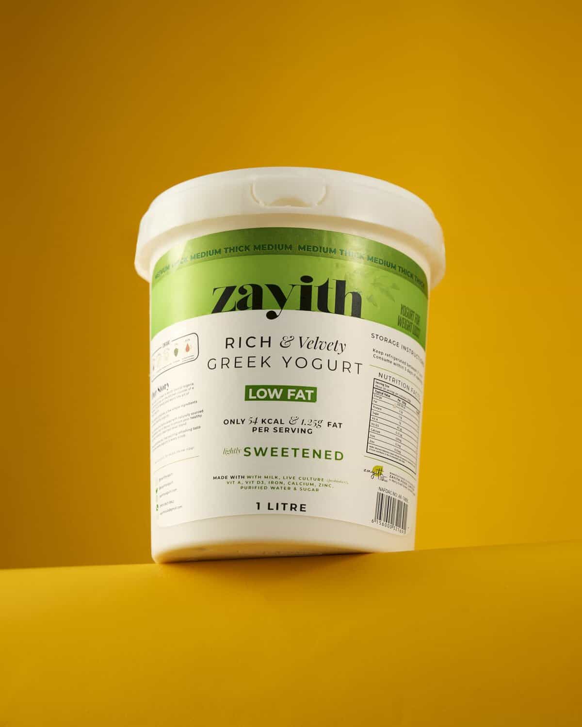 Zayith Low-Fat Sweetened Greek Yogurt 1 litre tub on a yellow background