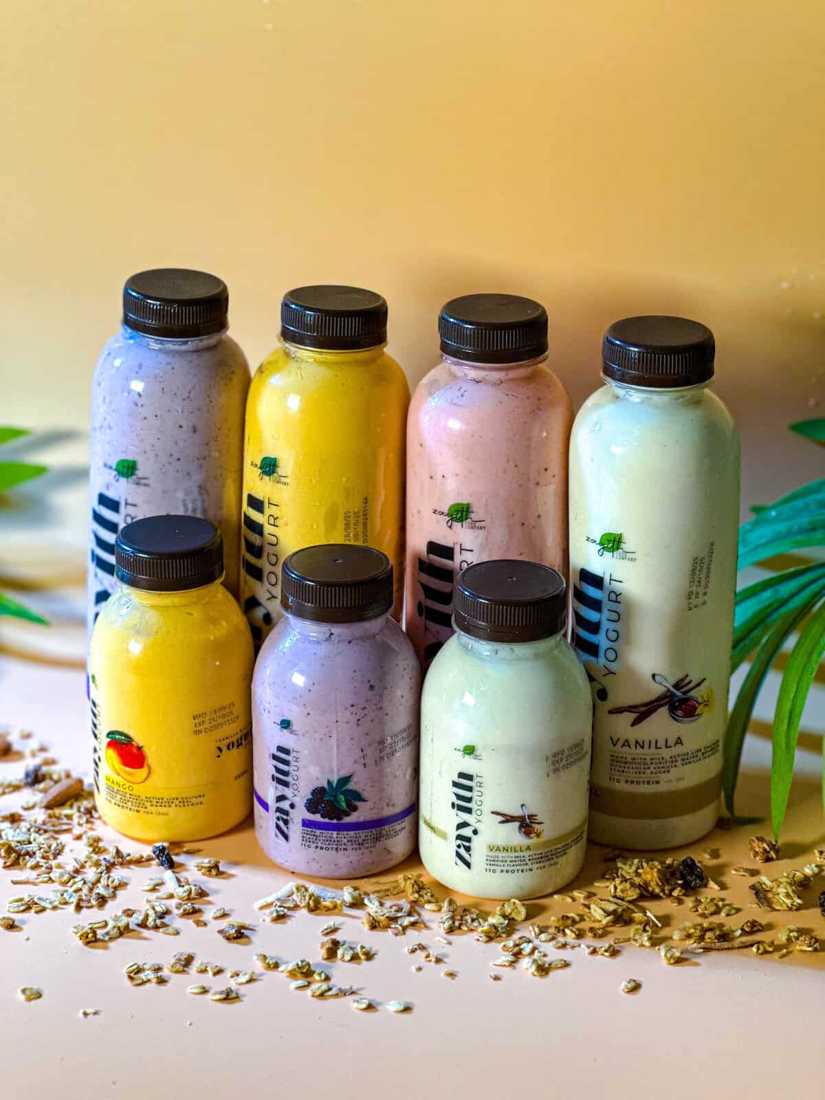 The Zayith yogurt drink range, mango, strawberry, mixed berry and vanilla, standing on scattered granola
